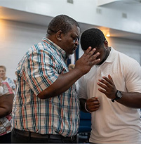 Elder praying for a young man