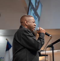 Elder praying with microphone.